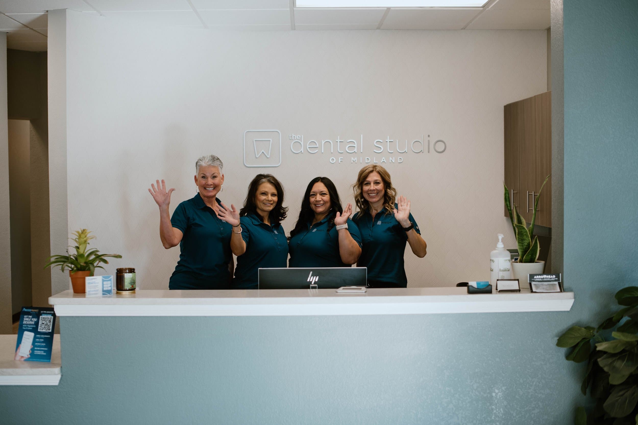 The front desk team waving hello at The Dental Studio of Midland